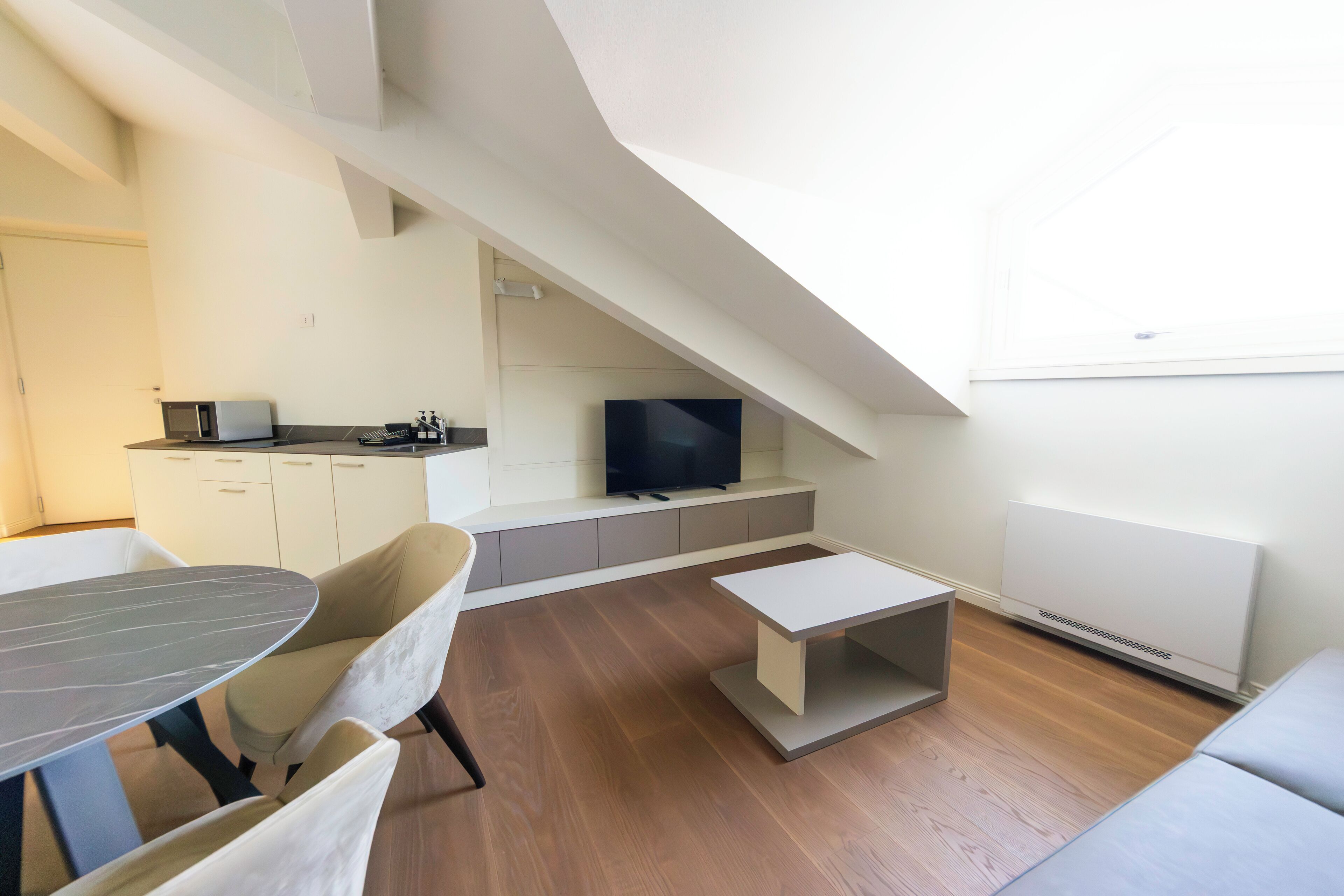 Ein modernes Wohnzimmer mit Essbereich, Flachbildfernseher und Kamin.