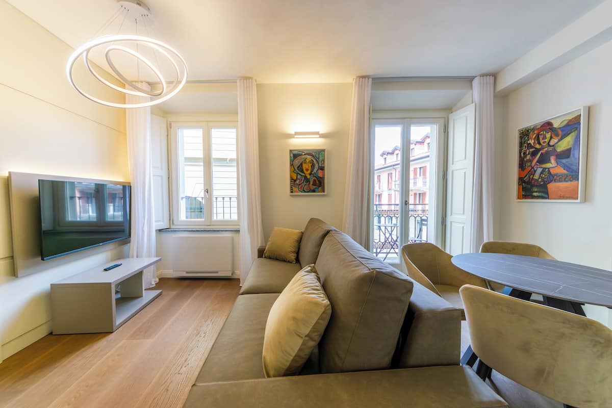 Uma sala de estar moderna com sofá, televisão e mesa de jantar.