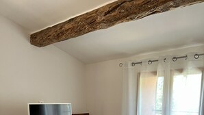 Ein Wohnzimmer mit einem Fernsehschrank aus Holz, einer Couch, einem Couchtisch aus Holz und einem Sessel.