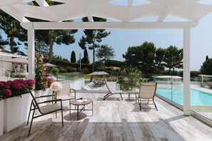 A covered outdoor area with a pool, lounge chairs, and a view of the surrounding landscape. - Nu Aria Taunus Relais  (Numana)