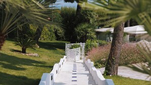 A white staircase leading up to a building, surrounded by greenery and a white fence. - Nu Aria Taunus Relais  (Numana)