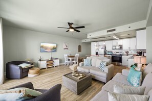 Un salon moderne comprenant un canapé, une table basse et un coin repas avec des chaises et une table.