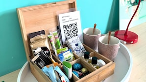 A wooden box with a QR code, a mug, a red lamp, and a framed picture on a table. - Flora's Palace (The Hague)