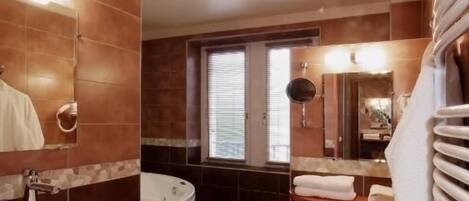 A modern bathroom with a large bathtub, a vanity with a sink, and a mirror.