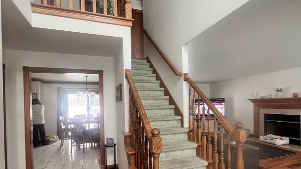 Amplia sala de estar con una escalera de madera que conduce a un nivel superior.