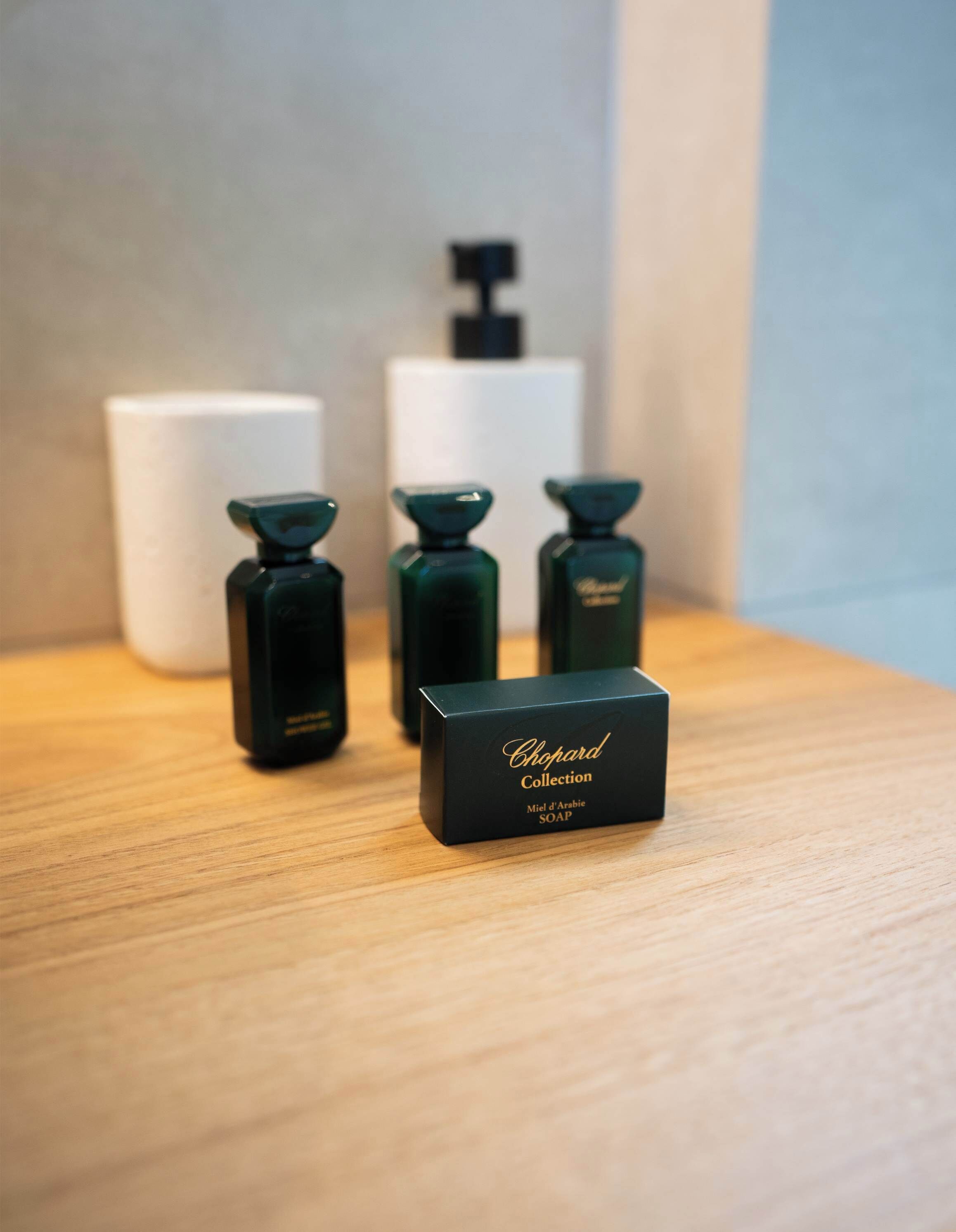 A display of Chopard Collection soap bottles and a box on a wooden surface.