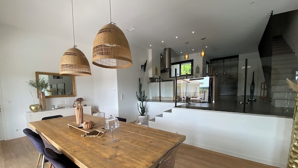 A modern kitchen with a wooden dining table, pendant lights, and a staircase leading to an upper level. - Superb villa with pool (Unknown)