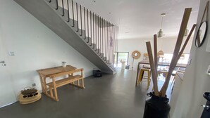 A modern interior with a wooden bench, a black trash bin, and a staircase with metal railings. - Superb villa with pool (Unknown)