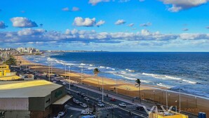A coastal cityscape with a beach, ocean, and a road leading to a building with a sign that reads "Hippodrome". - Art Studio by VLV Stays (Salvador)