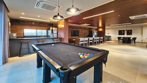 A pool table with balls, a bar area, and a dining space with chairs and tables. - Art Studio by VLV Stays (Salvador)