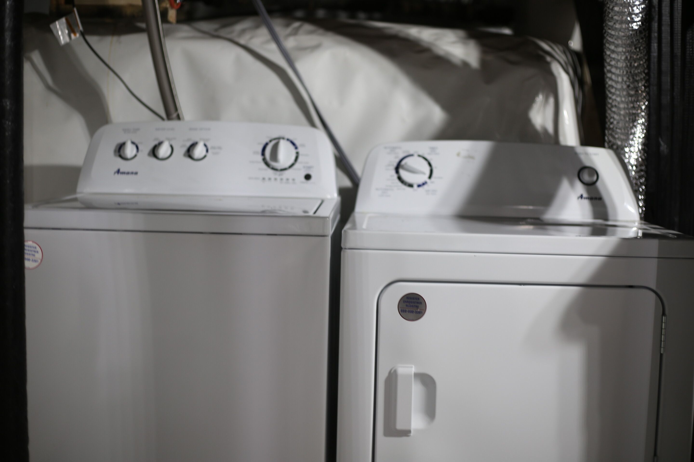 Deux machines à laver superposées dans une pièce.