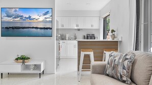 Een moderne keuken met witte kasten, een houten aanrecht en een inbouwfornuis.