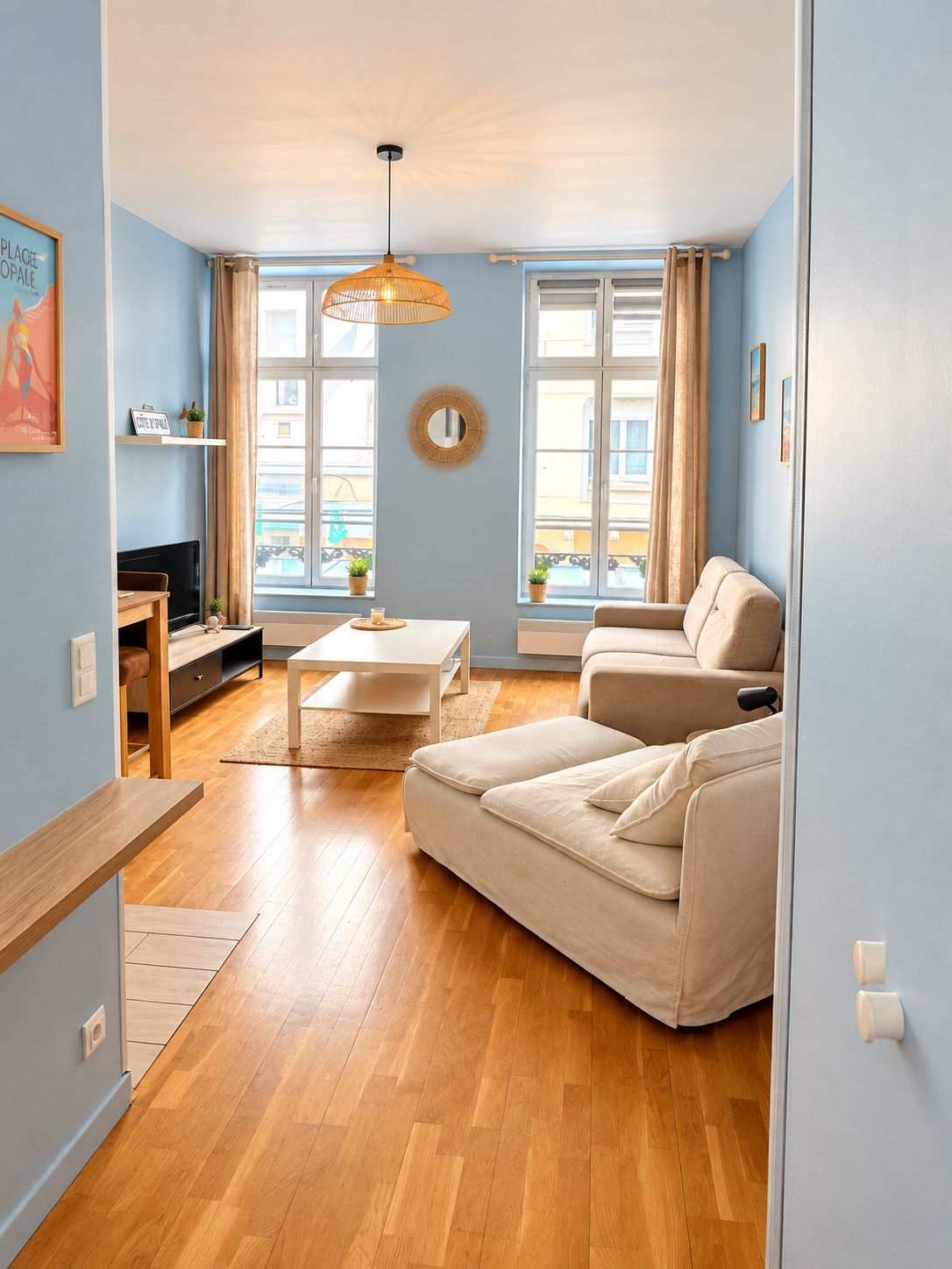 Una sala de estar con un sofá, una mesa de centro y un televisor sobre un mueble.