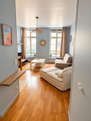 Ein modernes Wohnzimmer mit einer Couch, einem kleinen Tisch und einer Pendelleuchte.