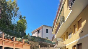 A parking area with several cars, a stone wall, and buildings with balconies. - Ferraretto cosy studio for 2 in Rapallo (Rapallo)