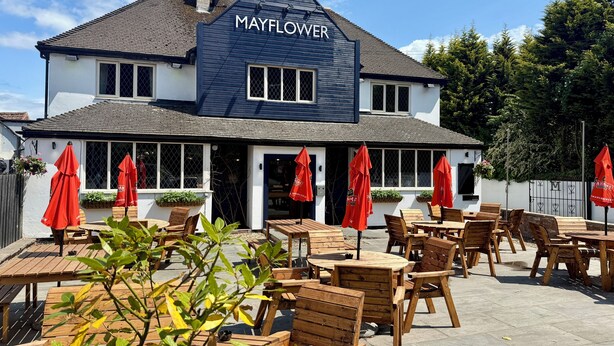 A two-story building named Mayflower with outdoor seating and red umbrellas. - The Mayflower at Austerfield (Doncaster)