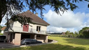 A two-story house with a balcony, a driveway, and a lawn. - Family home (Eymoutiers)