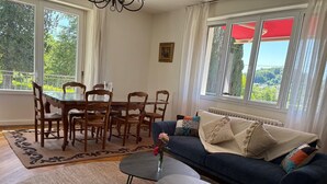 A living room with a dining table, chairs, a sofa, and a small coffee table. - Family home (Eymoutiers)