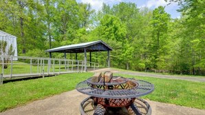 A metal fire pit with a circular metal table in the center, surrounded by a metal fence. - Private Guesthouse Retreat Near Kentucky Lake! (Dover)