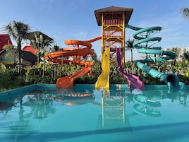 Parque aquático com várias escorregas e uma torre central.