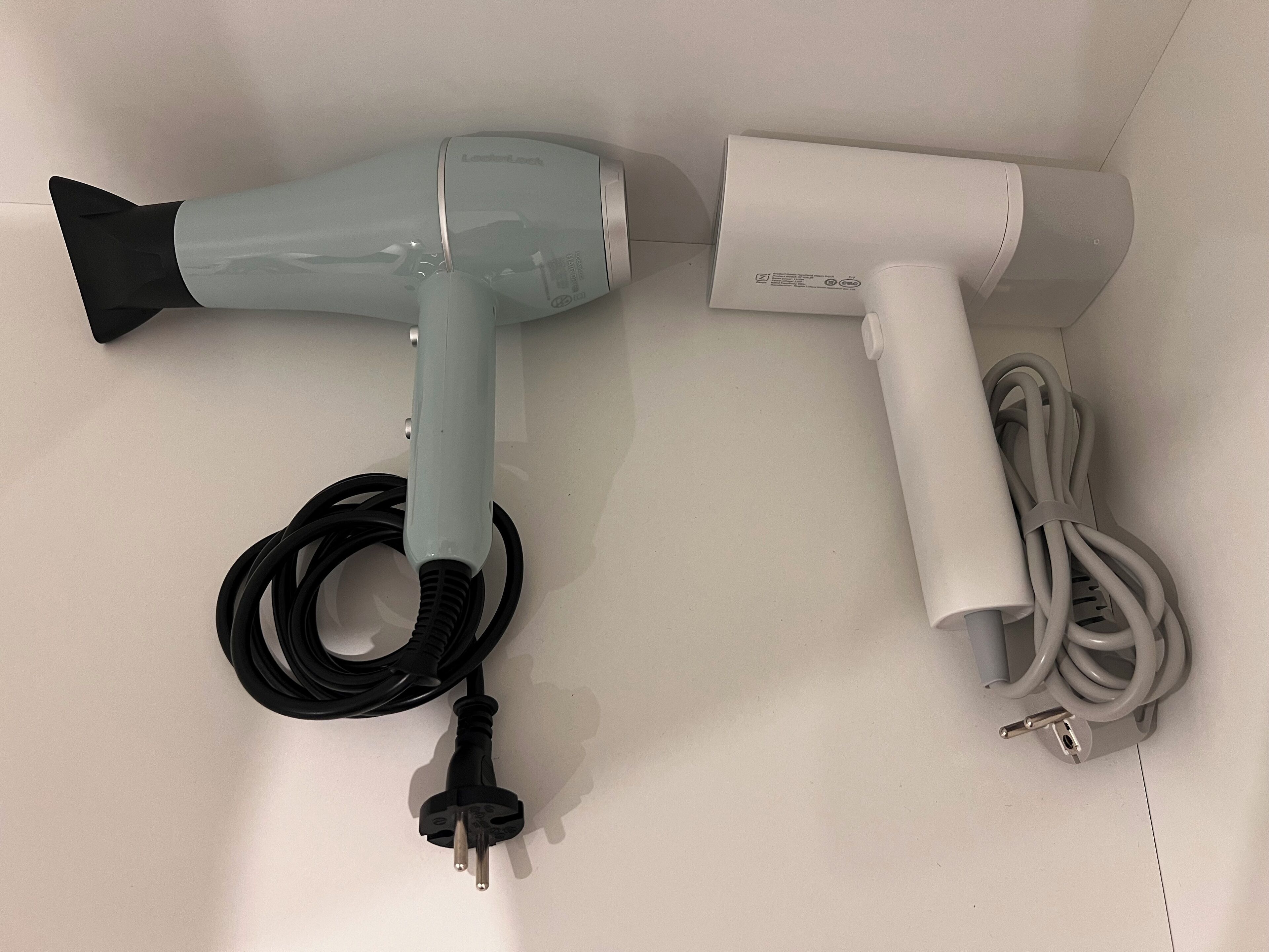 Een haardroger en bijbehorende accessoires op een witte ondergrond.