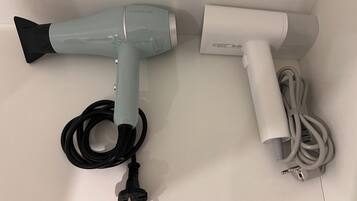 Een haardroger en bijbehorende accessoires op een witte ondergrond.
