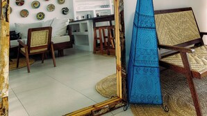 A room with a large mirror, a blue decorative panel, and a wall adorned with various plates. - Villa Kweli (Makunduchi)