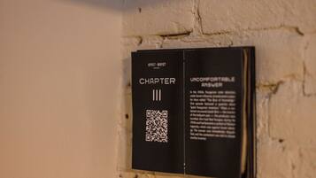 A black plaque with text and a QR code on a wall.