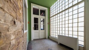 A hallway with a green wall, a white door, and a radiator. - East-West Boutique Hotel Budapest (Budapest)