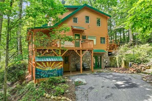 Uma cabana de toras com varanda, alicerce de pedra e uma placa com o dizer 'Morning Star Asheville'.