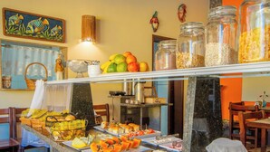 A buffet with various food items and a pitcher of juice. - Vivenda do Flamboyant  (Ubatuba)