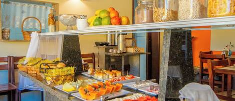 A buffet with various food items and a pitcher of juice.