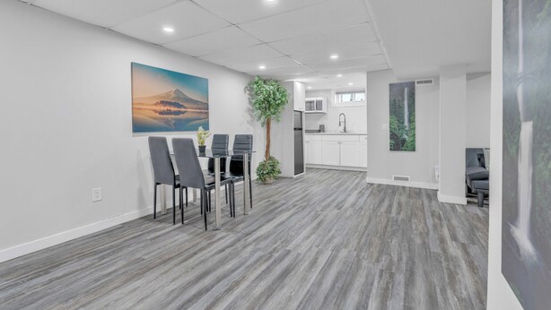 A modern office space with a dining area, a kitchen, and a living area. - Luxury Basement Suite in Top Prime Location (Winnipeg)