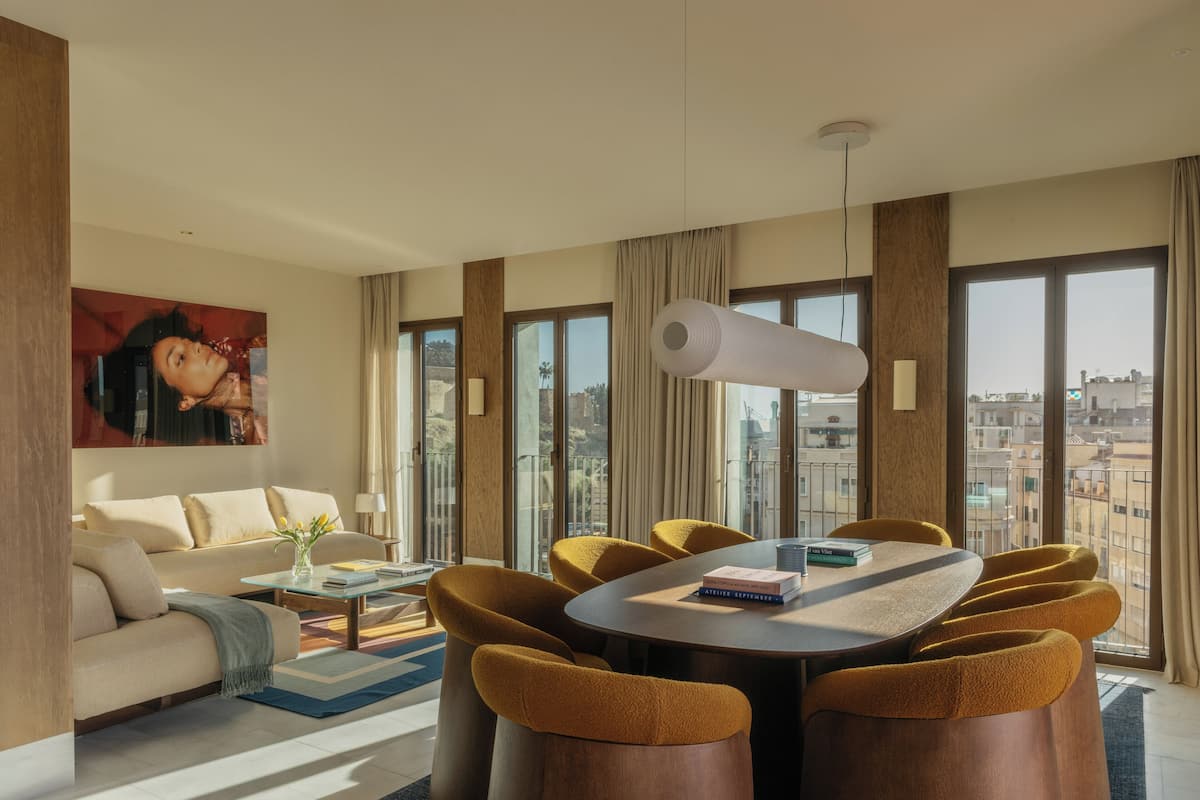 Una sala de estar moderna con un sofá, una mesa de centro y un comedor con sillas y una mesa.