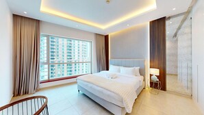 Een moderne hotelkamer met een groot bed, uitzicht op de stad en een balkon.