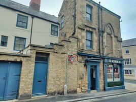 A Victorian-style building with a 'Give Way' sign, a blue door, and a shop named 'The Victorian Tap'.