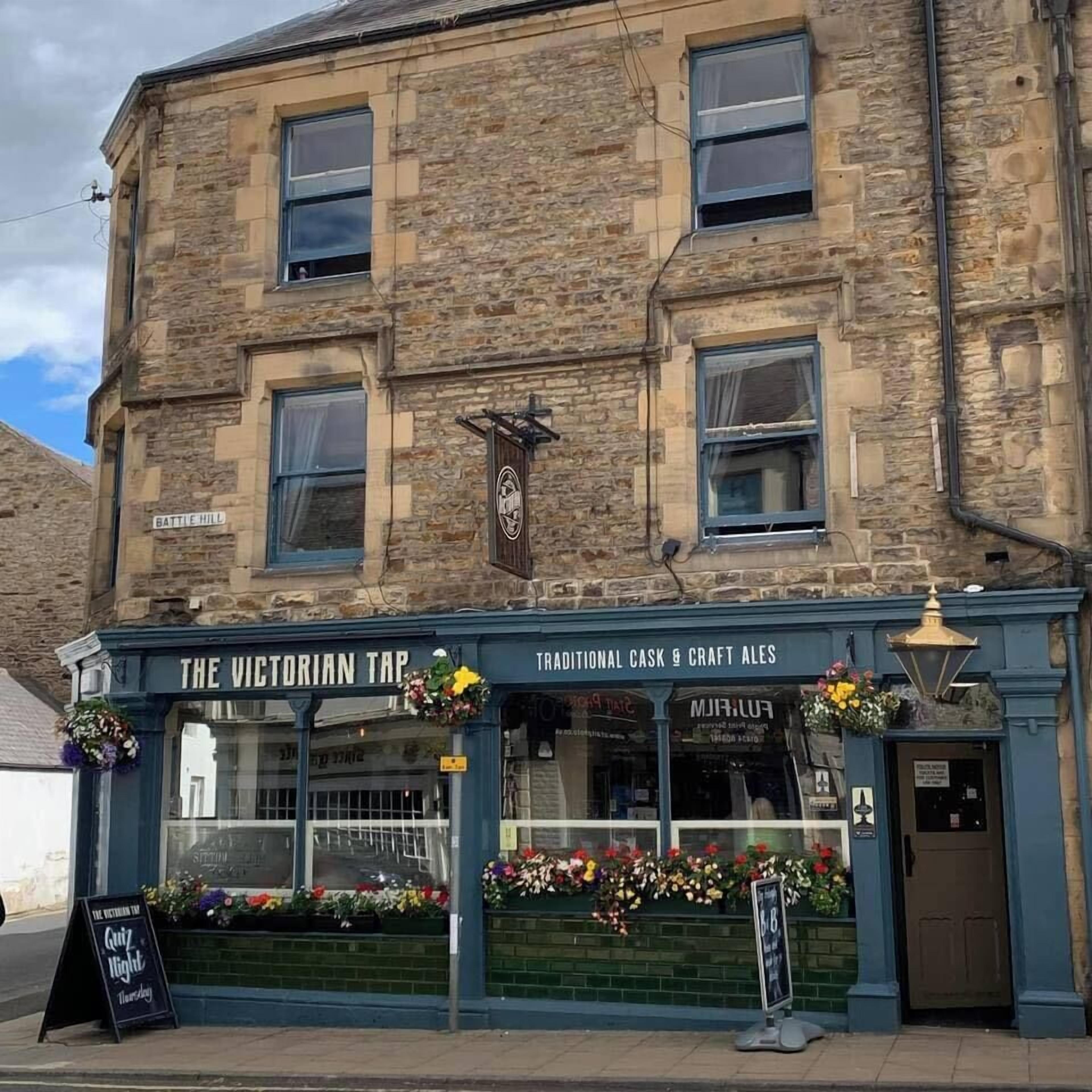 Un edificio tradicional con un letrero que dice 'The Victorian Tap' y 'Traditional Cask & Craft Ales'.