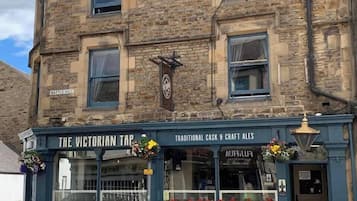 Un edificio tradicional con un letrero que dice 'The Victorian Tap' y 'Traditional Cask & Craft Ales'.