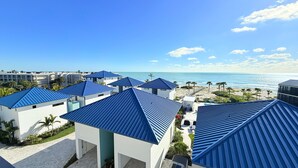 A resort with multiple buildings featuring blue roofs, a beach, and a clear view of the ocean. - Shalimar Beach Resort (Sanibel)