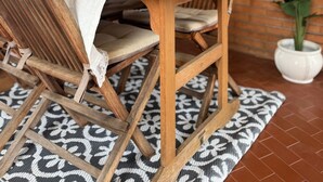 Une table de salle à manger en bois, recouverte d’une nappe blanche et entourée de chaises rembourrées.