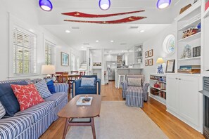 A spacious living room with a sofa, armchairs, a coffee table, and a fireplace. - Seabatical! 3BR 2BA Coastal Retreat for 8 Relax, Unwind, and Recharge (Panama City Beach)