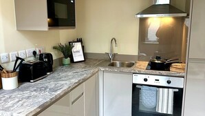Una cocina moderna con horno empotrado, pileta de acero inoxidable y microondas.