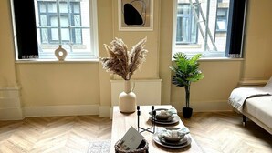 Una habitación con una mesa de centro de madera, una planta en maceta y un sofá.