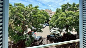 A view of a parking lot with several cars, surrounded by trees and buildings in the background. - Angie By Terry's Homes (Cannes)