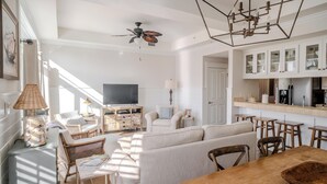 Ein großzügiger Wohnbereich mit Sofa, Holztisch und Fernseher.
