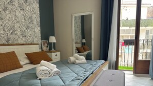 A bedroom with a bed, bedside tables, a mirror, and a view of the outside. - Provencal style suite (second floor) (Licata)
