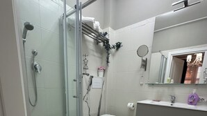 A modern bathroom with a glass-enclosed shower, a toilet, and a vanity with a mirror. - Provencal style suite (second floor) (Licata)