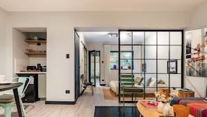 A modern living space with a kitchen, dining area, and a sofa set.