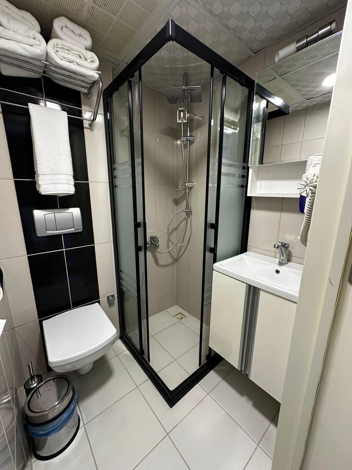 Une salle de bain moderne avec une douche à parois de verre, un lavabo blanc et des toilettes.