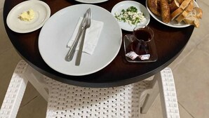 Una mesa de desayuno con diversos platos que incluyen huevos, pan y verduras.